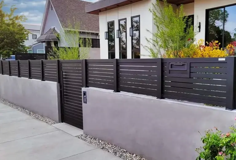 Gros plan d’un panneau de clôture d’intimité en aluminium montrant la finition à grain de bois avec revêtement en poudre qui conserve sa couleur et son lustre pendant des décennies