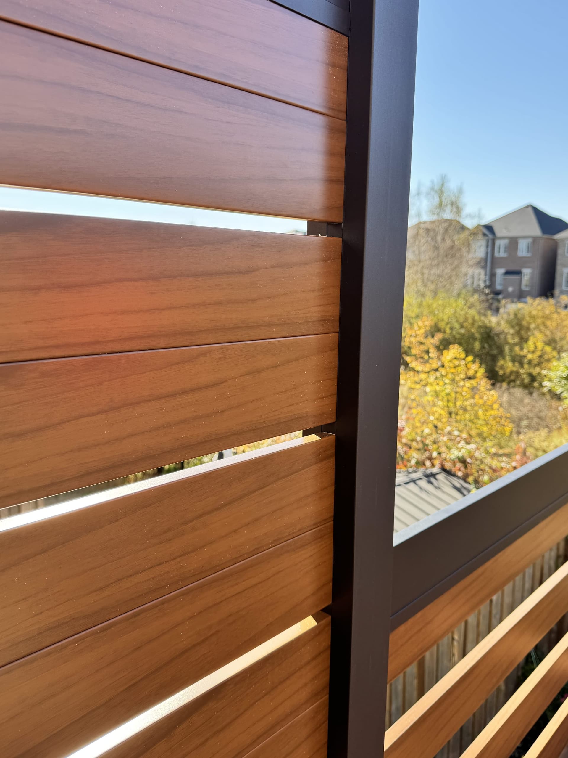 Clôture d’intimité en aluminium installée par des professionnels le long d’une terrasse dans une cour arrière canadienne