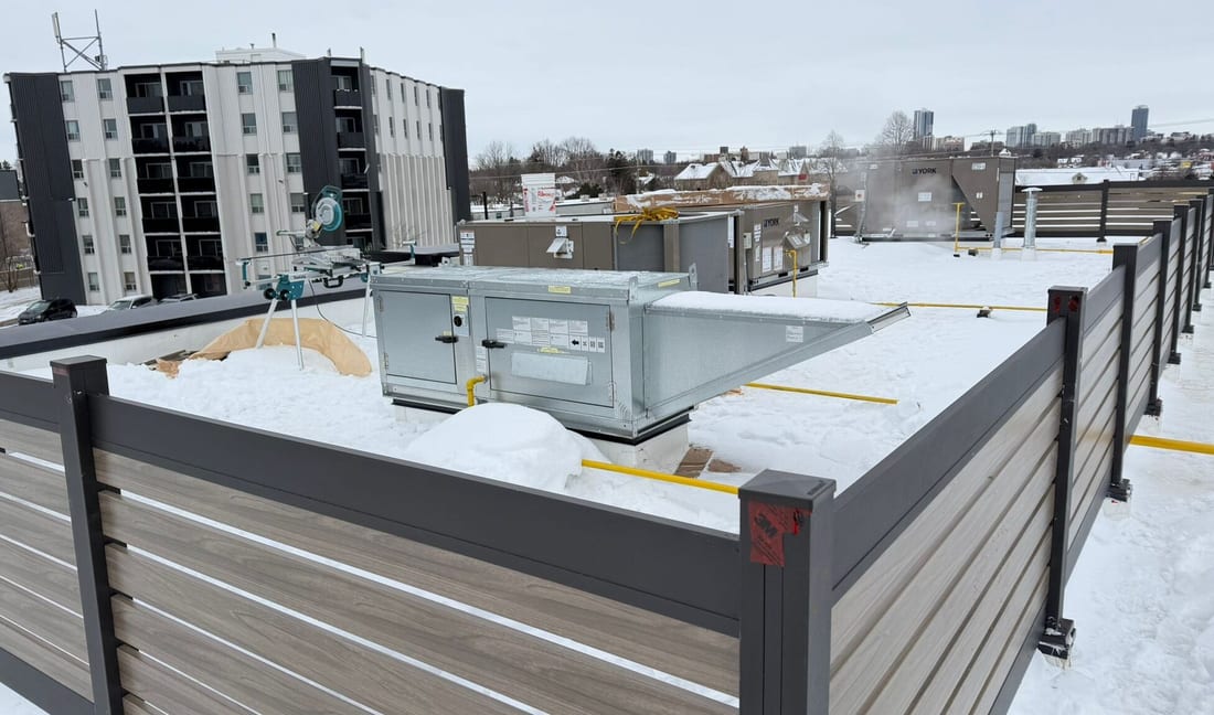 Aluminum privacy fence panel installed on a rooftop, screening mechanical equipment