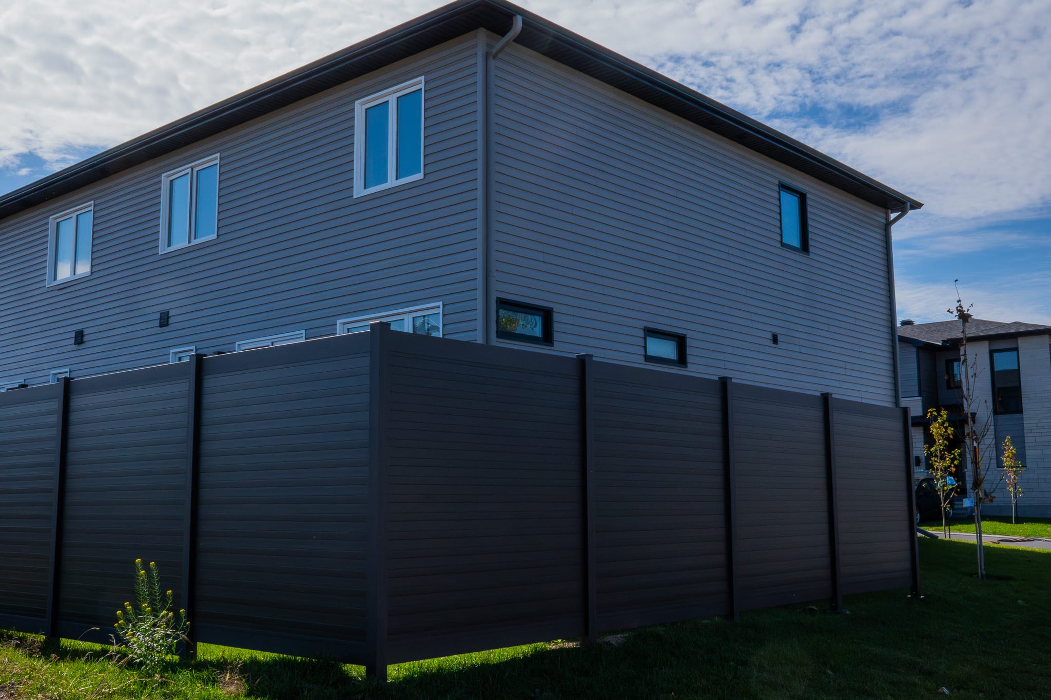 Close-up of an installed aluminum fence panel showing the rail-to-post junction in a Canadian residential yard